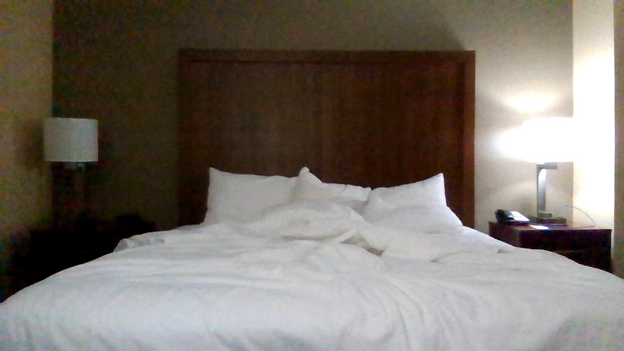 Hotel bed slept in, pillows rumpled