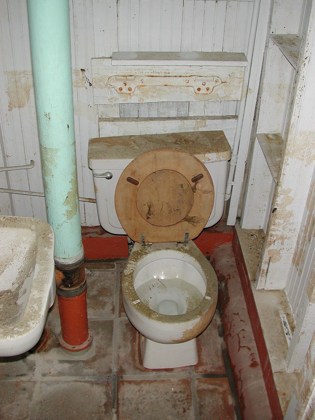 Dirty toilet and stained bathroom floor